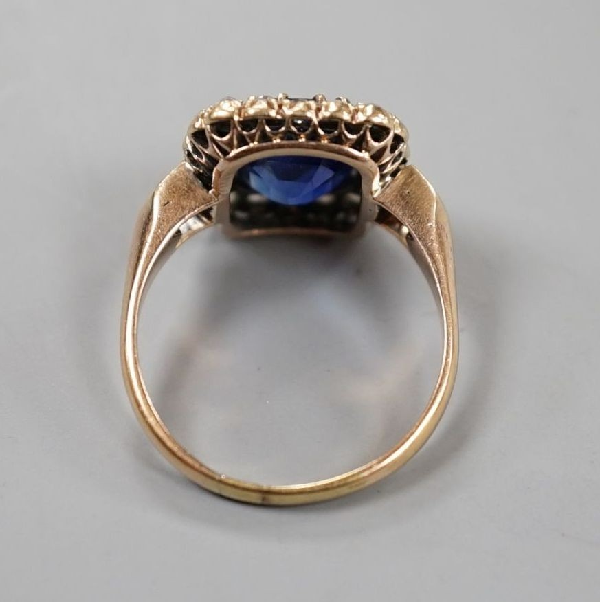 An early 20th century yellow metal, synthetic sapphire and old cut diamond set rectangular cluster ring, size N, gross weight 4.6 grams, with diamond set shoulders.